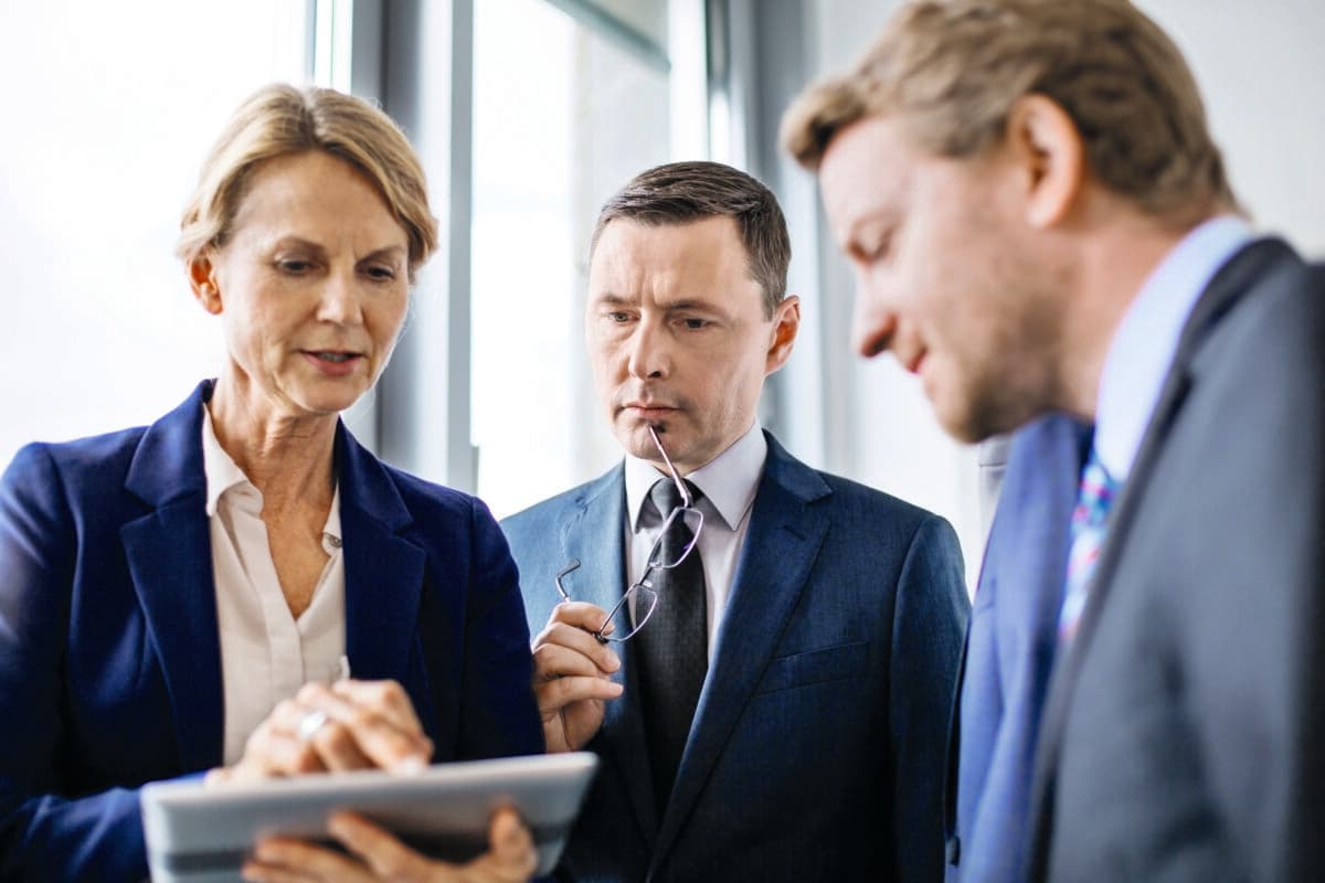 Mature businesswoman viewing proposal to colleagues